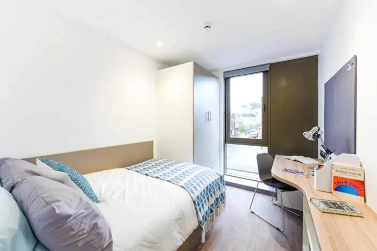 Bed wardrobe desk with books and lamp bedroom at Great Patrick Street in Belfast Student Accommodation