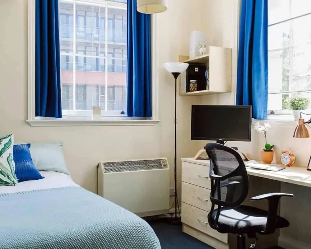 Bed desk chair computer and radiator bedroom at Queen's Hospital Close in Birmingham Student Accommodation