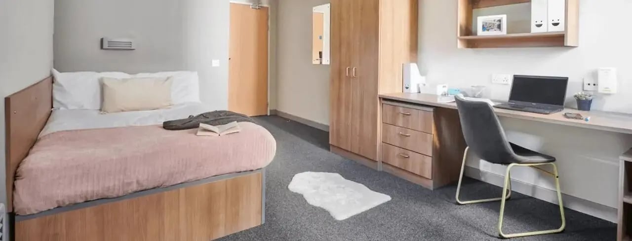 Bed desk wardrobe with laptop and chair bedroom at Northfield in Exeter Student Accommodation