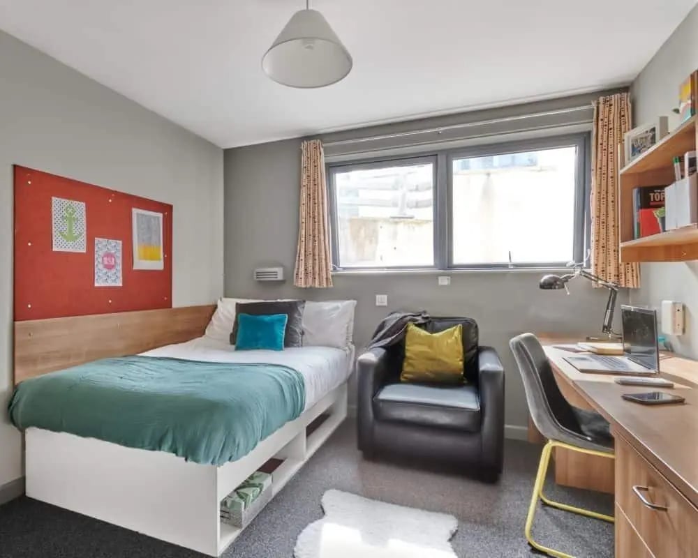 Bed chair desk laptop bookshelf bedroom at Northfield in Exeter Student Accommodation