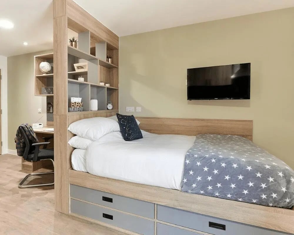 Bed with star blanket desk shelves TV bedroom at Southampton Crossings in Southampton Student Accommodation