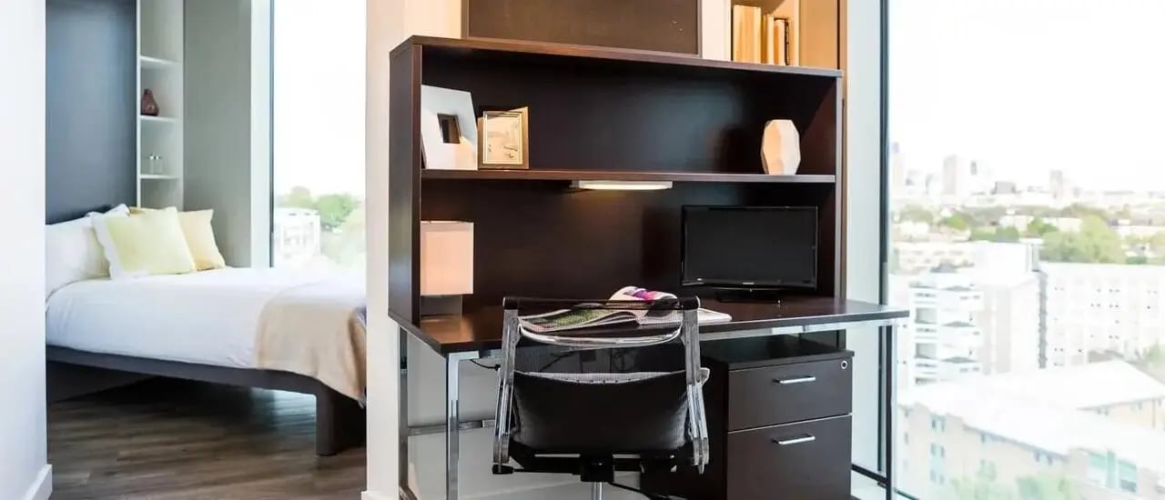 Bed and desk with monitor and chair bedroom study area at Chapter Kings Cross in London Student Accommodation