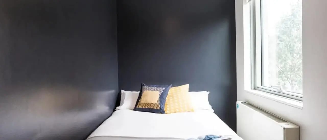 Bed with pillows radiator and window bedroom at Chapter Kings Cross in London Student Accommodation