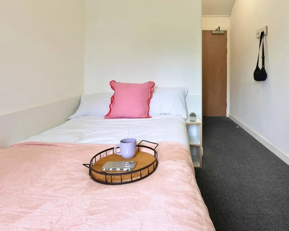 Bed with pink blanket and tray bedroom at The Village at The Viaduct in Durham Student Accommodation