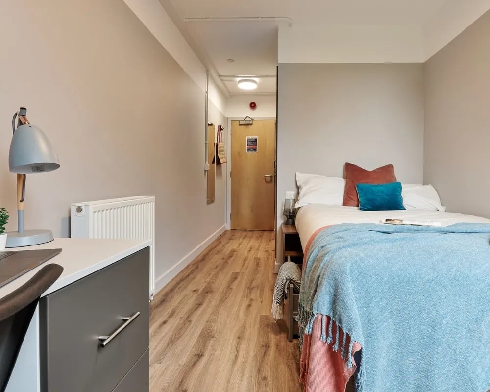 Bed desk radiator hallway and door bedroom at The Helix in London Student Accommodation