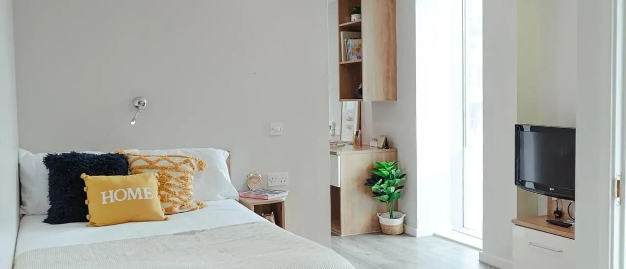 Bed with pillows desk and TV bedroom at Chapter South Bank in London Student Accommodation