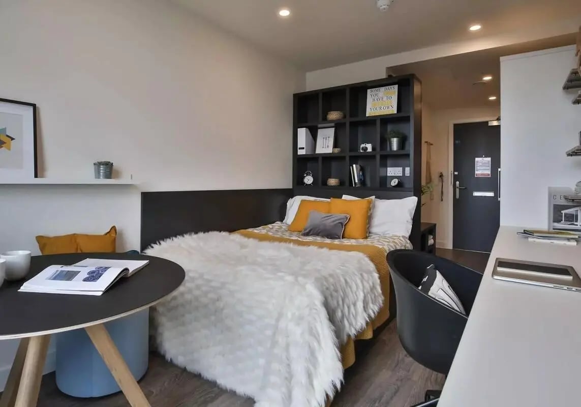 Bed with fluffy throw shelf and desk Bedroom at iQ Shoreditch in London Student Accommodation