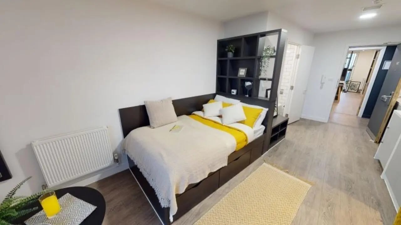 Bed with shelves radiator and table bedroom at iQ Shoreditch in London Student Accommodation
