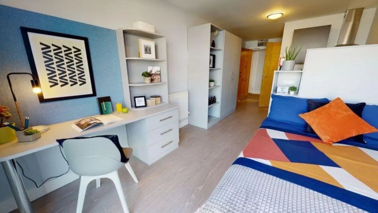 Desk with lamp bookshelf bed living room bedroom at iQ Hoxton in London Student Accommodation