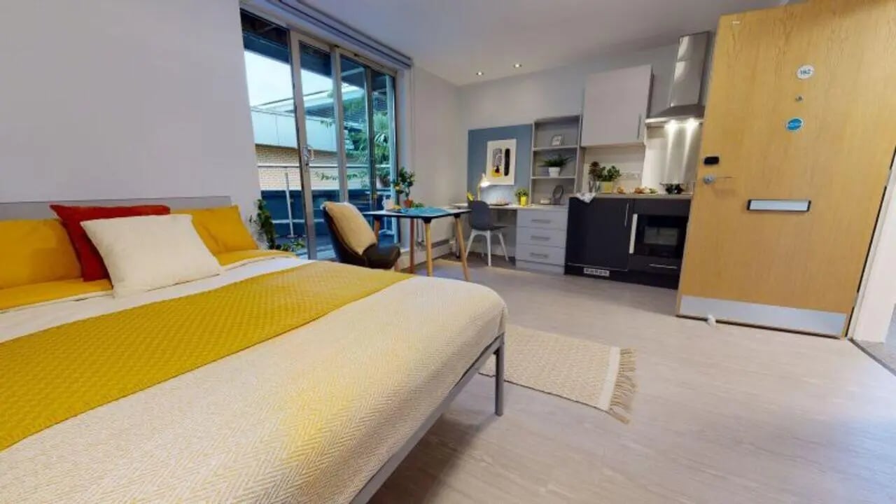 Bed desk kitchenette with oven and door Studio at iQ Hoxton in London Student Accommodation