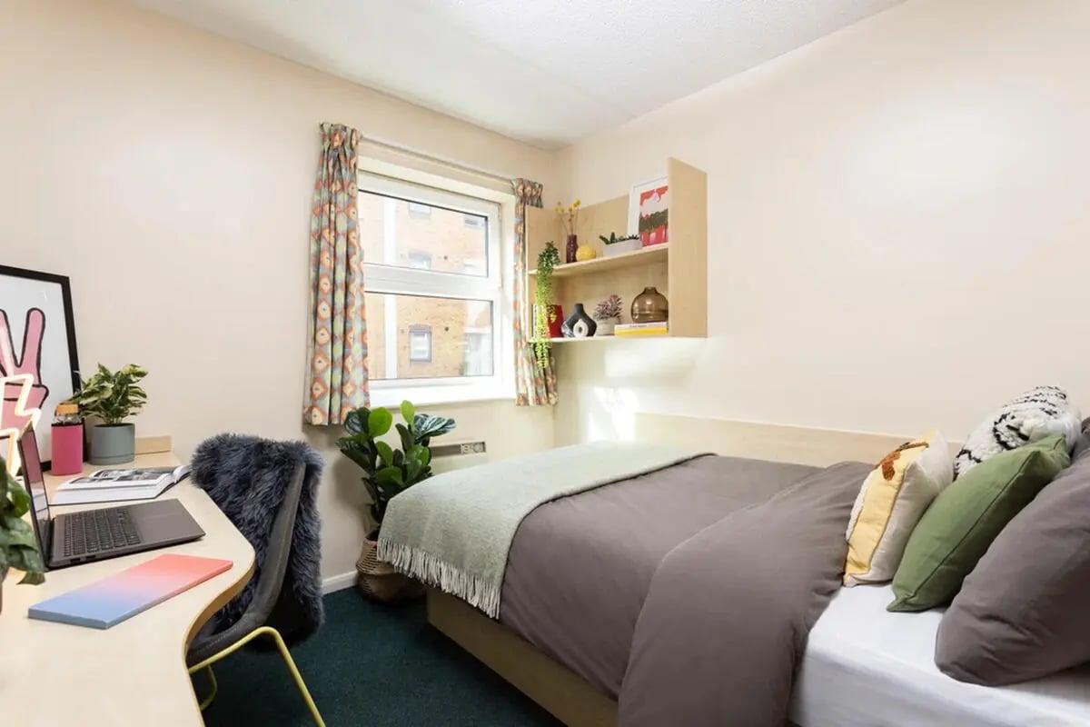 Desk laptop plant bed with pillows bedroom at Leadmill Point in Sheffield Student Accommodation