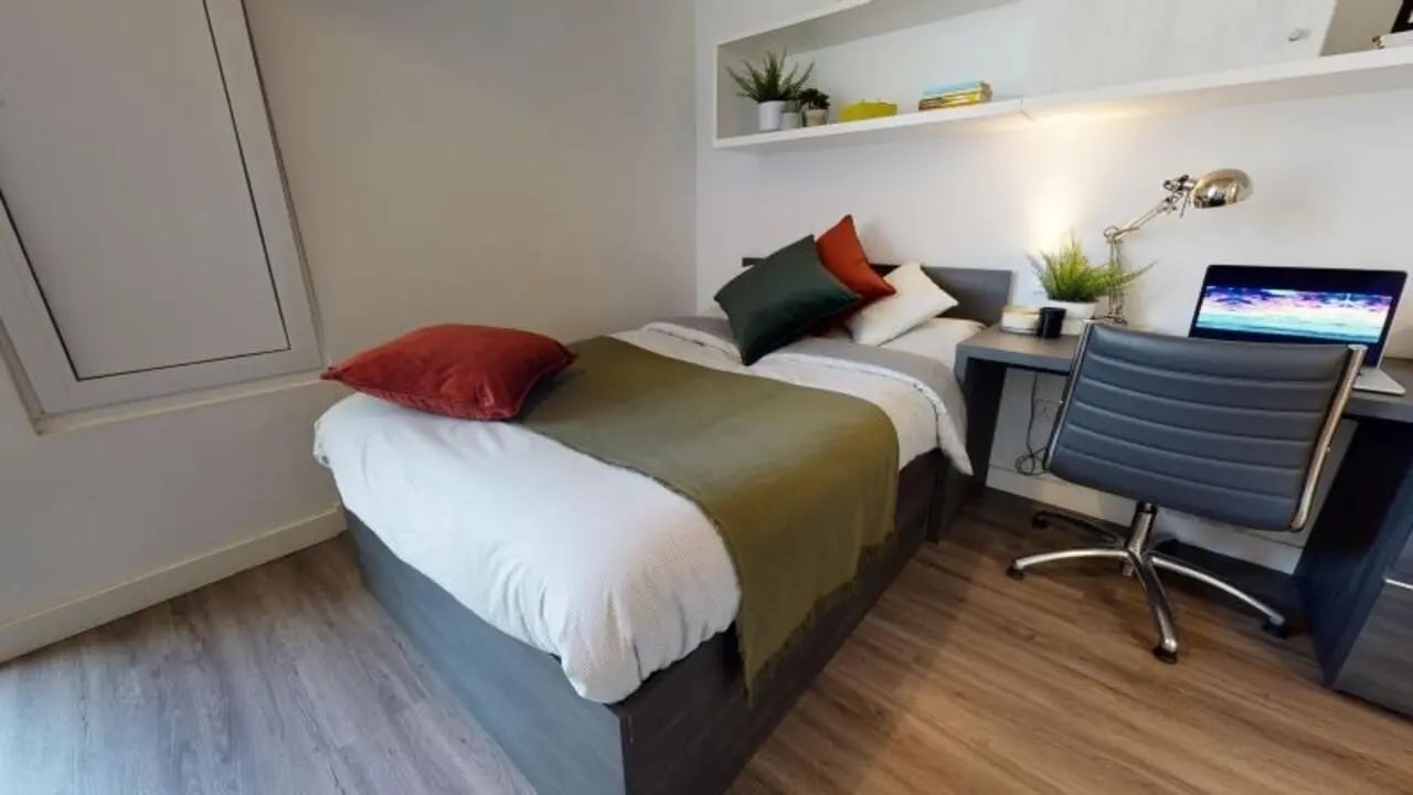Bed desk chair laptop and plants bedroom at iQ Aldgate in London Student Accommodation