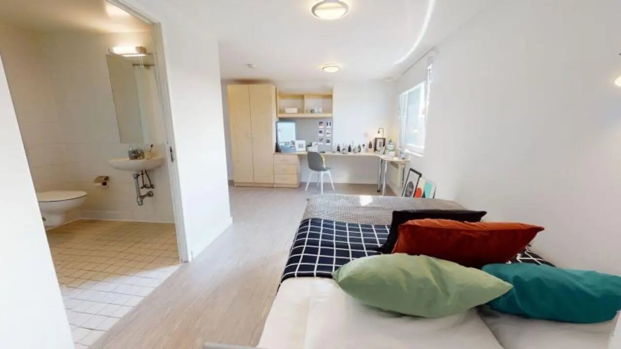 Bed with pillows toilet sink wardrobe study area bedroom at iQ Marsden House in Leeds Student Accommodation
