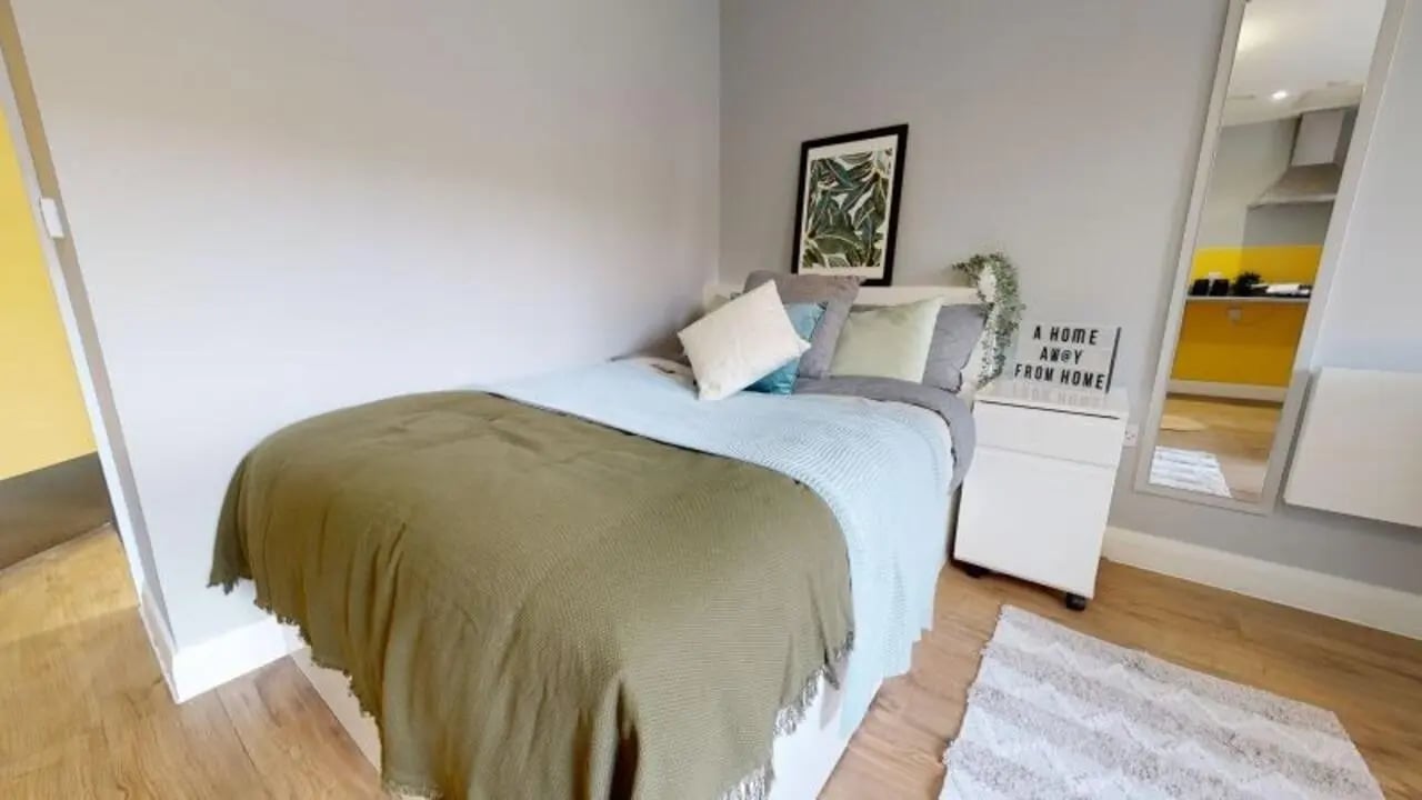 Bed with pillows blanket and framed art bedroom at iQ The Brickworks in York Student Accommodation
