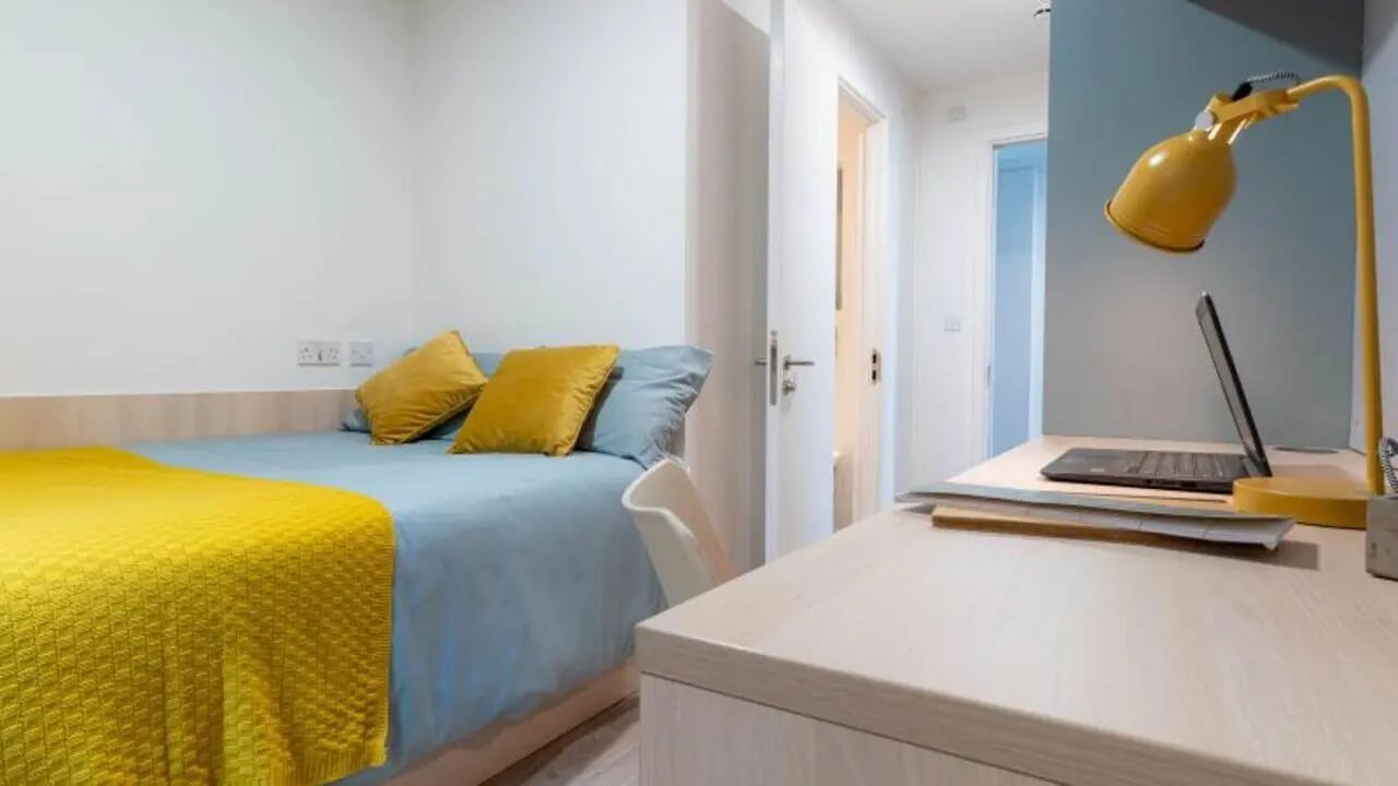Bed desk laptop yellow lamp bedroom study area at iQ Signal Place in Nottingham Student Accommodation
