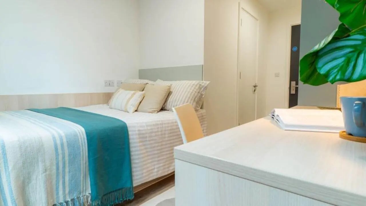 Bed with blue and white throws study desk bedroom at iQ Signal Place in Nottingham Student Accommodation