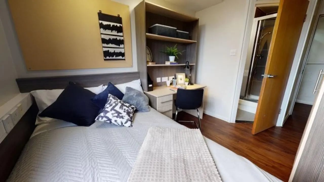 Bed desk bookshelf and shower bedroom at iQ Lambert & Fairfield House in Manchester Student Accommodation