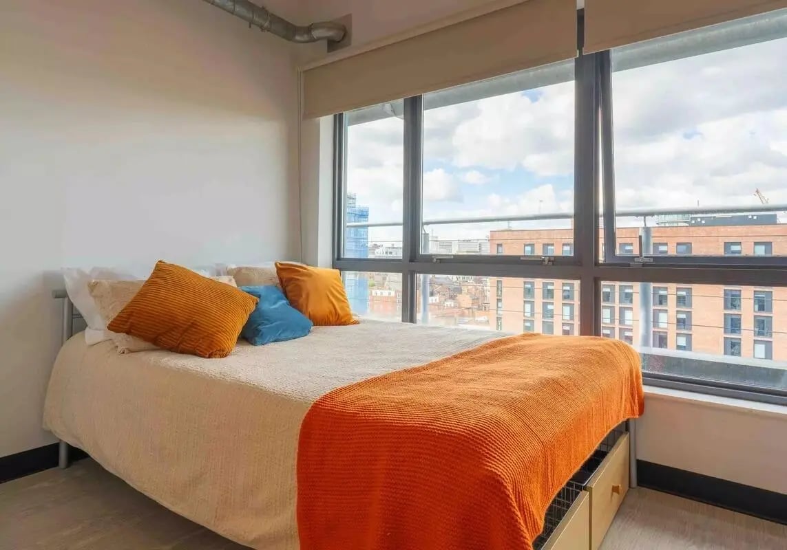 Bed with orange blue pillows view bedroom at iQ Exchange in Nottingham Student Accommodation