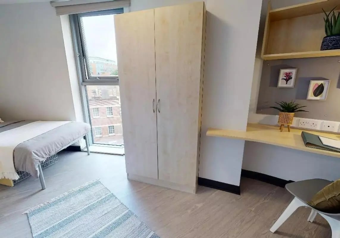 Bed desk wardrobe and framed pictures bedroom at iQ Exchange in Nottingham Student Accommodation