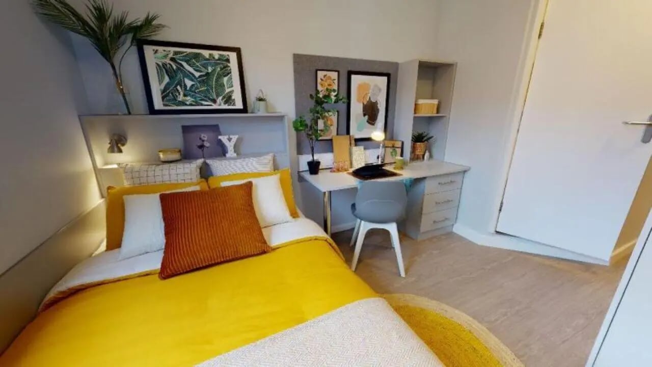 Yellow bed desk chair artwork bedroom interior at iQ Will Wyatt Court in London Student Accommodation