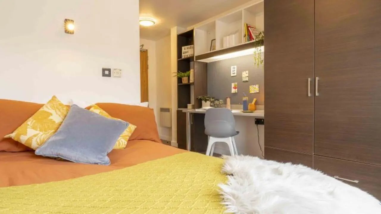 Bed pillows desk chair shelves wardrobe bedroom at iQ Astor House in Plymouth Student Accommodation