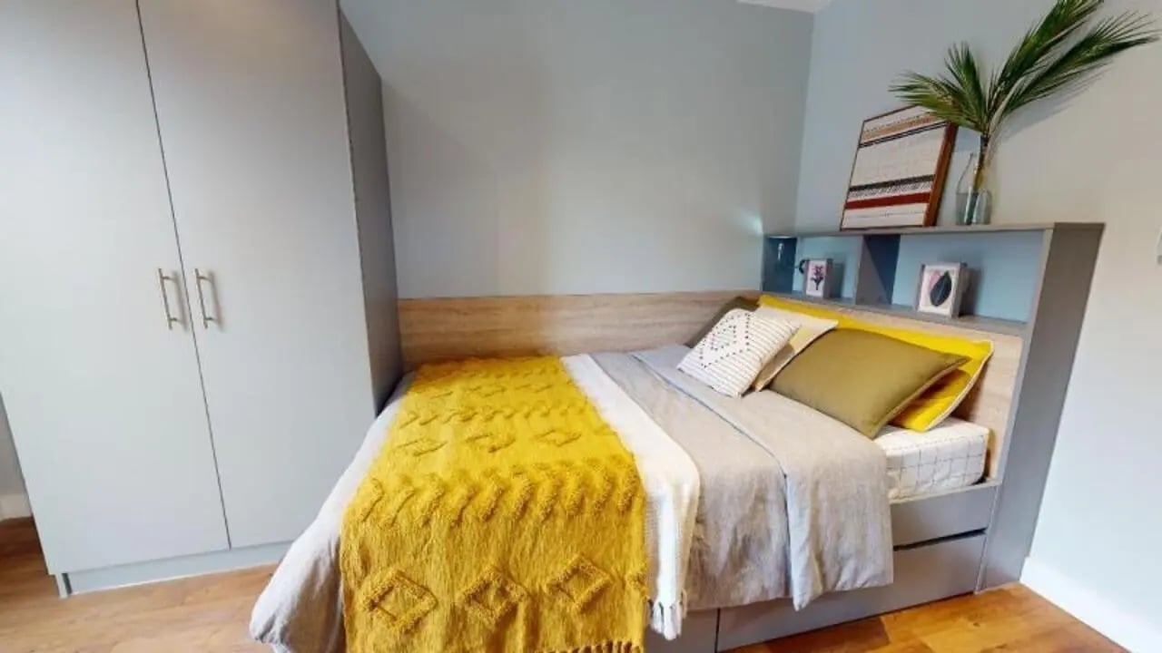 Wardrobe bed with yellow throw and pillows Bedroom at iQ Knight House in Sheffield Student Accommodation