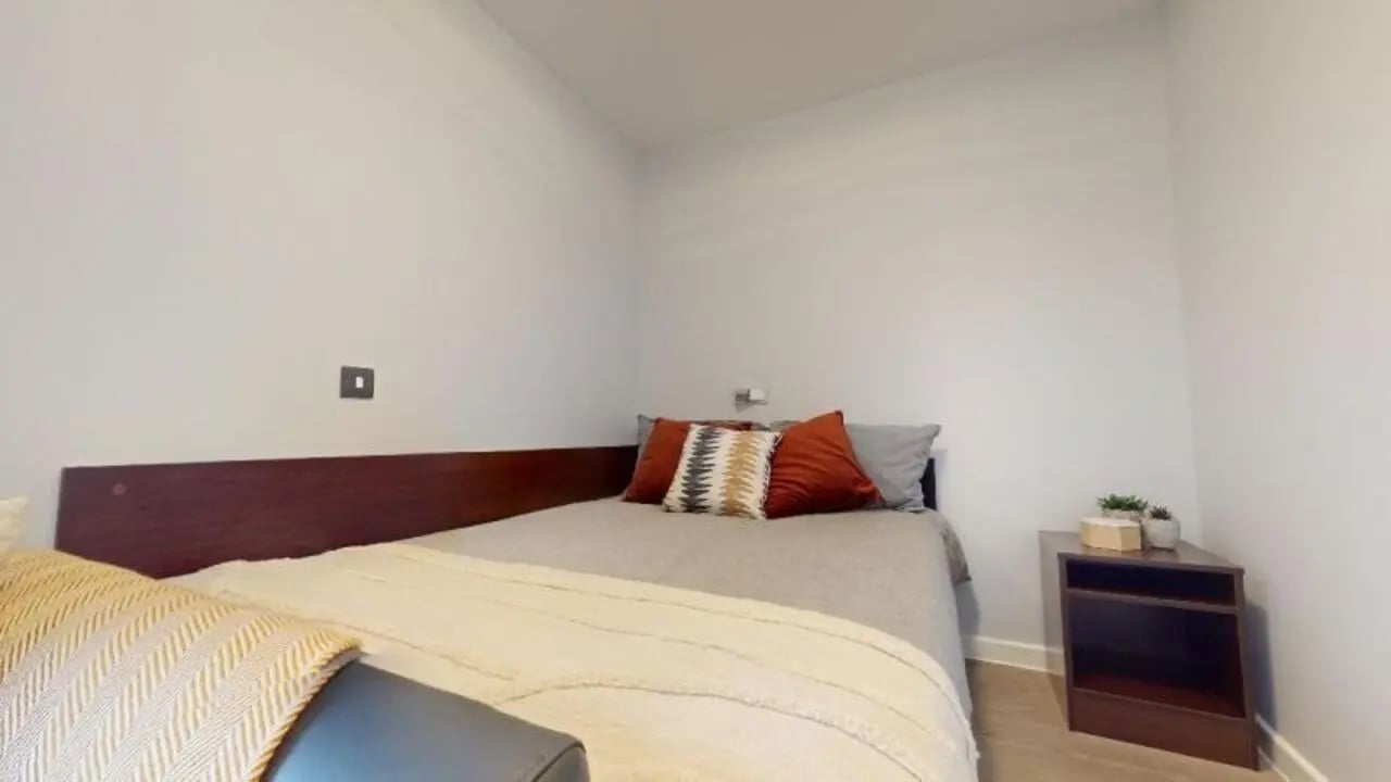 Bed with pillows bedside table bedroom at iQ Highbury in London Student Accommodation