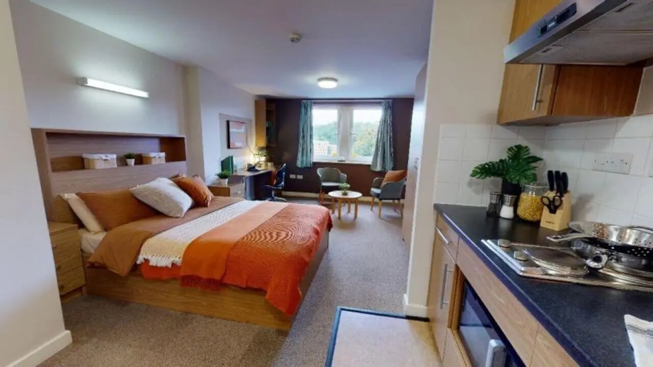 Bed desk chairs and kitchen unit studio apartment at iQ Leeds in Leeds Student Accommodation