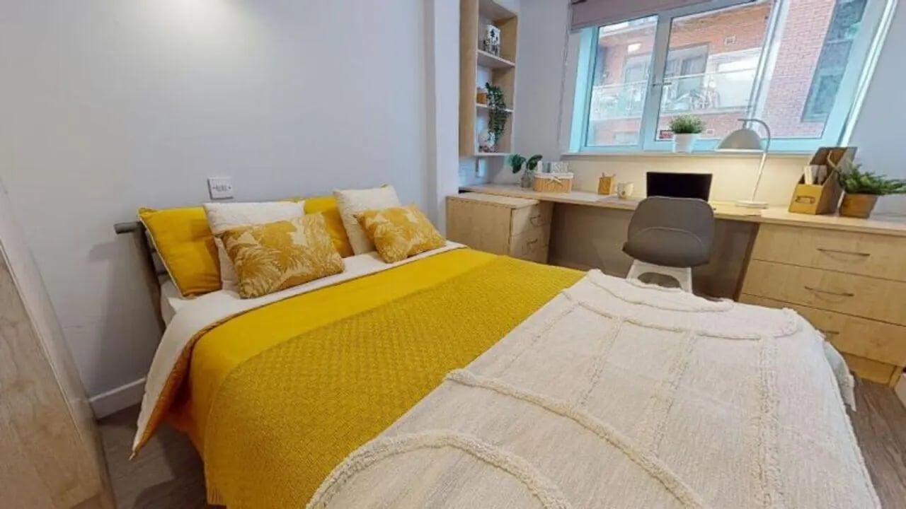 Yellow bed desk with laptop and chair bedroom at iQ Fenton House in Sheffield Student Accommodation