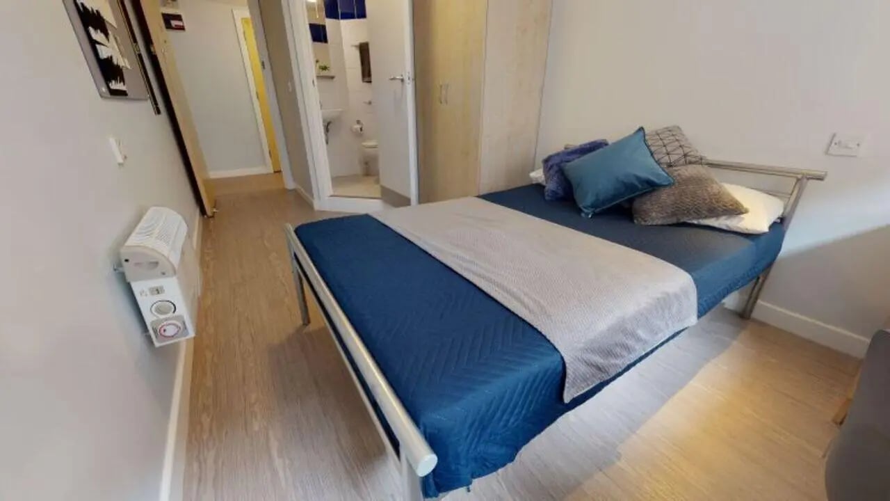 Bed with blue bedding and pillows bedroom at iQ Fenton House in Sheffield Student Accommodation