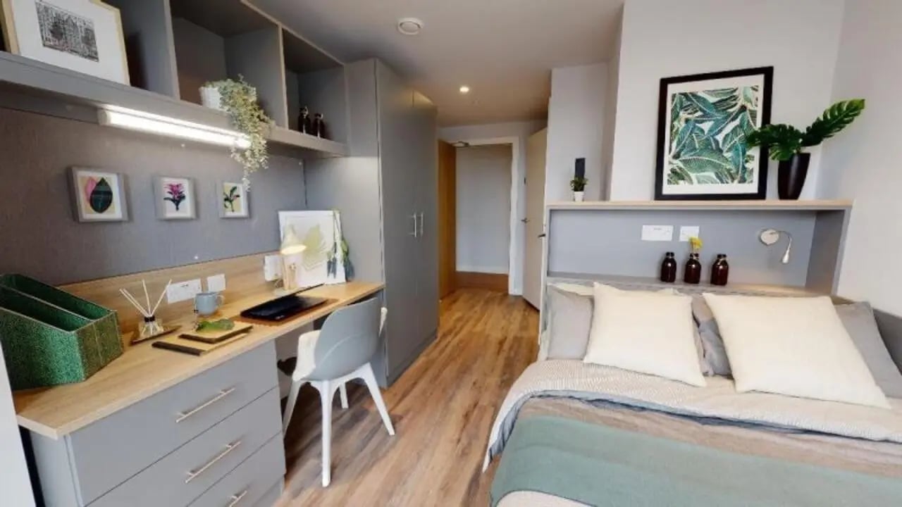 Desk bed shelves plants artwork bedroom at iQ Altus House in Leeds Student Accommodation