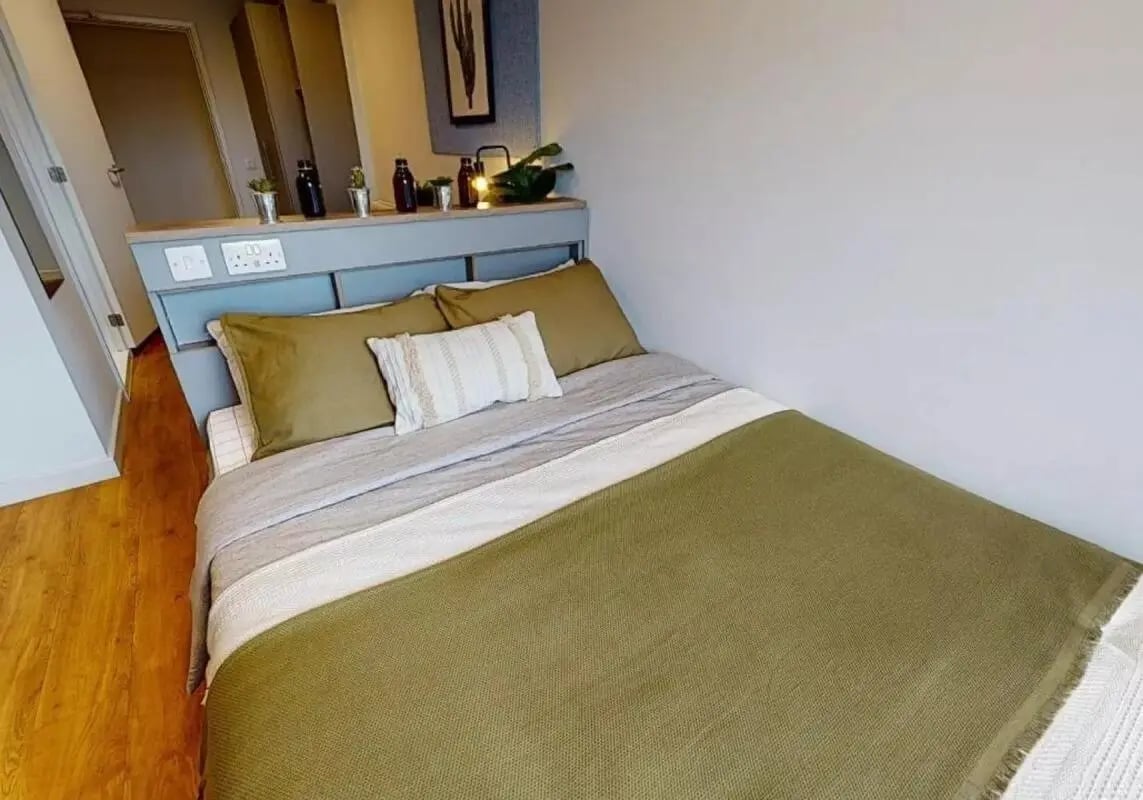 Bed with green and grey bedding bedding bedroom at iQ Collingwood in Newcastle Upon Tyne Student Accommodation