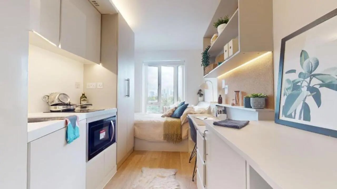 Kitchenette bed desk shelves and artwork student studio at iQ East Court in London Student Accommodation
