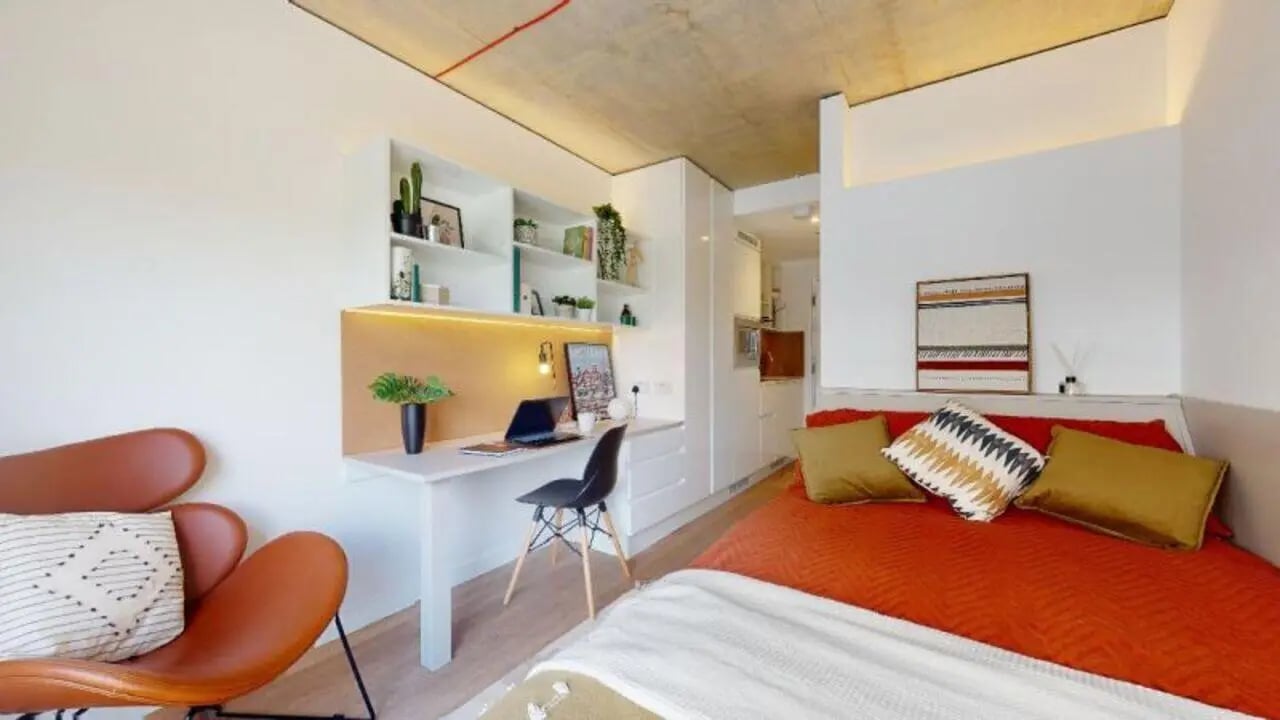 Bed desk chair and chair living room at iQ Flinders House in London Student Accommodation