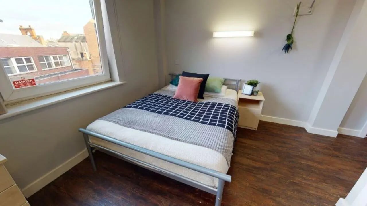Bed with pillows and blankets bedside table bedroom at iQ Grosvenor House in Leicester Student Accommodation