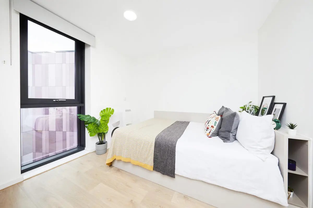 Bed with plants and pillows bedroom at Collegiate Bagot Street in Birmingham Student Accommodation