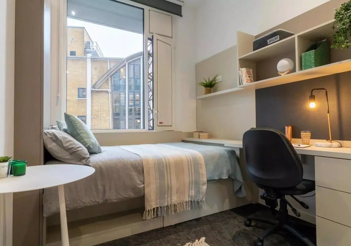 Bed desk and shelves with belongings bedroom at iQ Vega London in London Student Accommodation