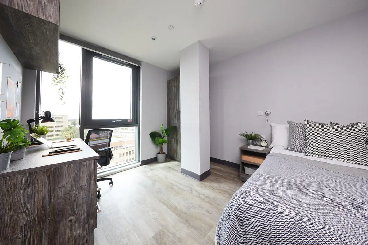 Desk chair plants and bed in room Bedroom at Collegiate Crown Place Norwich in Norwich Student Accommodation