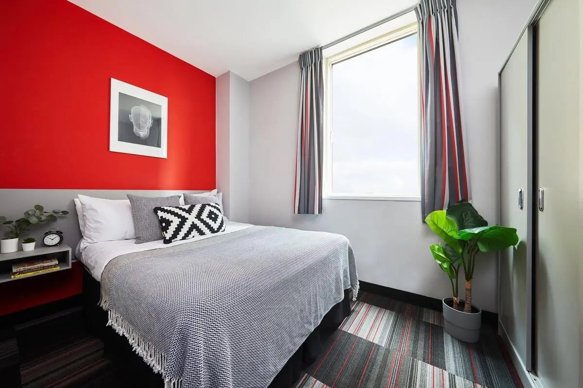 Bed bedside table artwork plant and wardrobe bedroom at Corporation Village in Coventry Student Accommodation