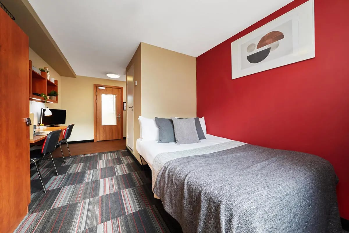 Bed desk chairs shelves and door bedroom at Corporation Village in Coventry Student Accommodation