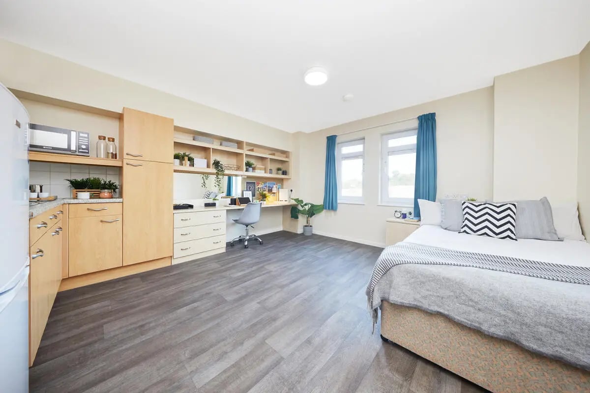 Kitchen desk bed with dresser and shelves bedroom at Collegiate King Edward Studios in Exeter Student Accommodation