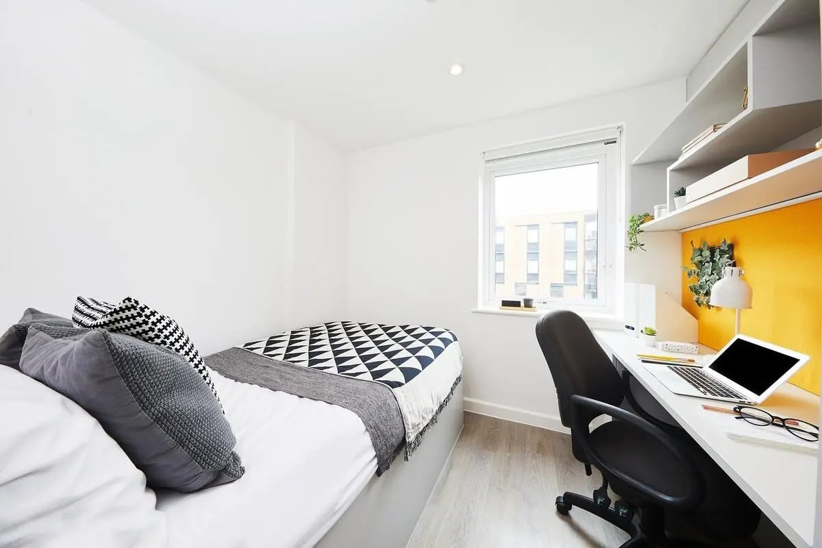 Bed desk chair laptop bookshelf bedroom study area at Collegiate Riverside Way Winchester in Winchester Student Accommodation