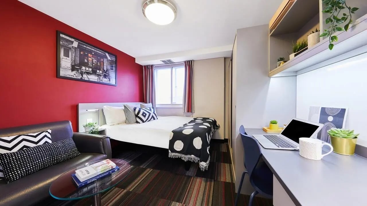 Bed sofa desk plants and laptop bedroom at The Moor in Sheffield Student Accommodation