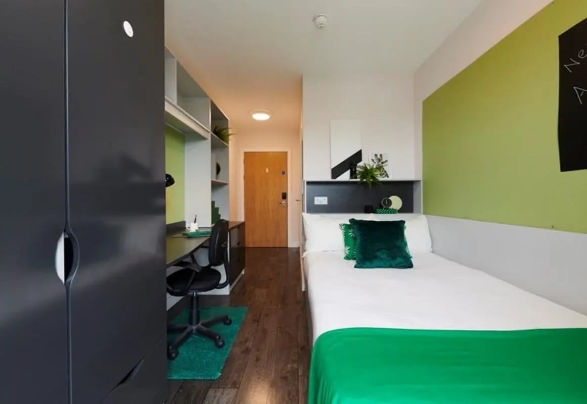 Wardrobe desk chair bed with green accents Bedroom at Binary Hub in Dublin Student Accommodation
