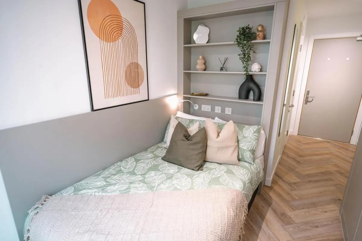 Bed with leaf pattern duvet and bookshelf bedroom at Cork Street Residence in Dublin Student Accommodation