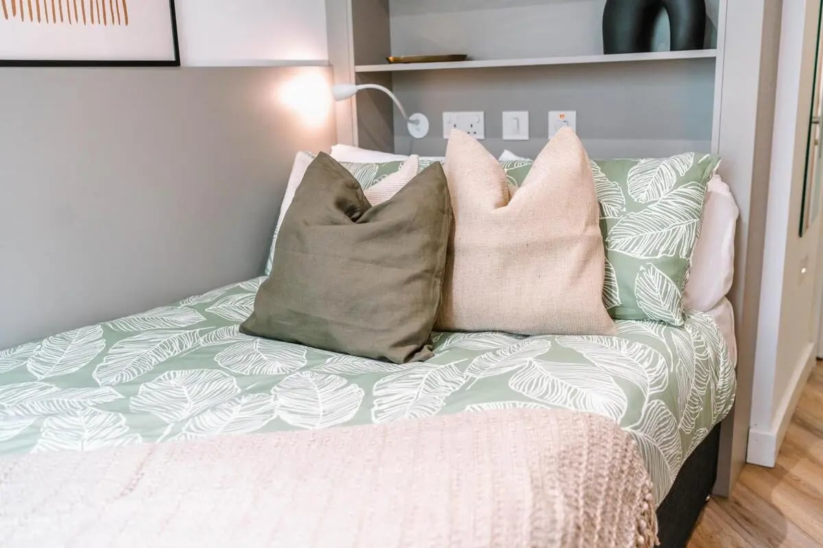 Bed with green leaf bedding and pillows bedroom at Cork Street Residence in Dublin Student Accommodation