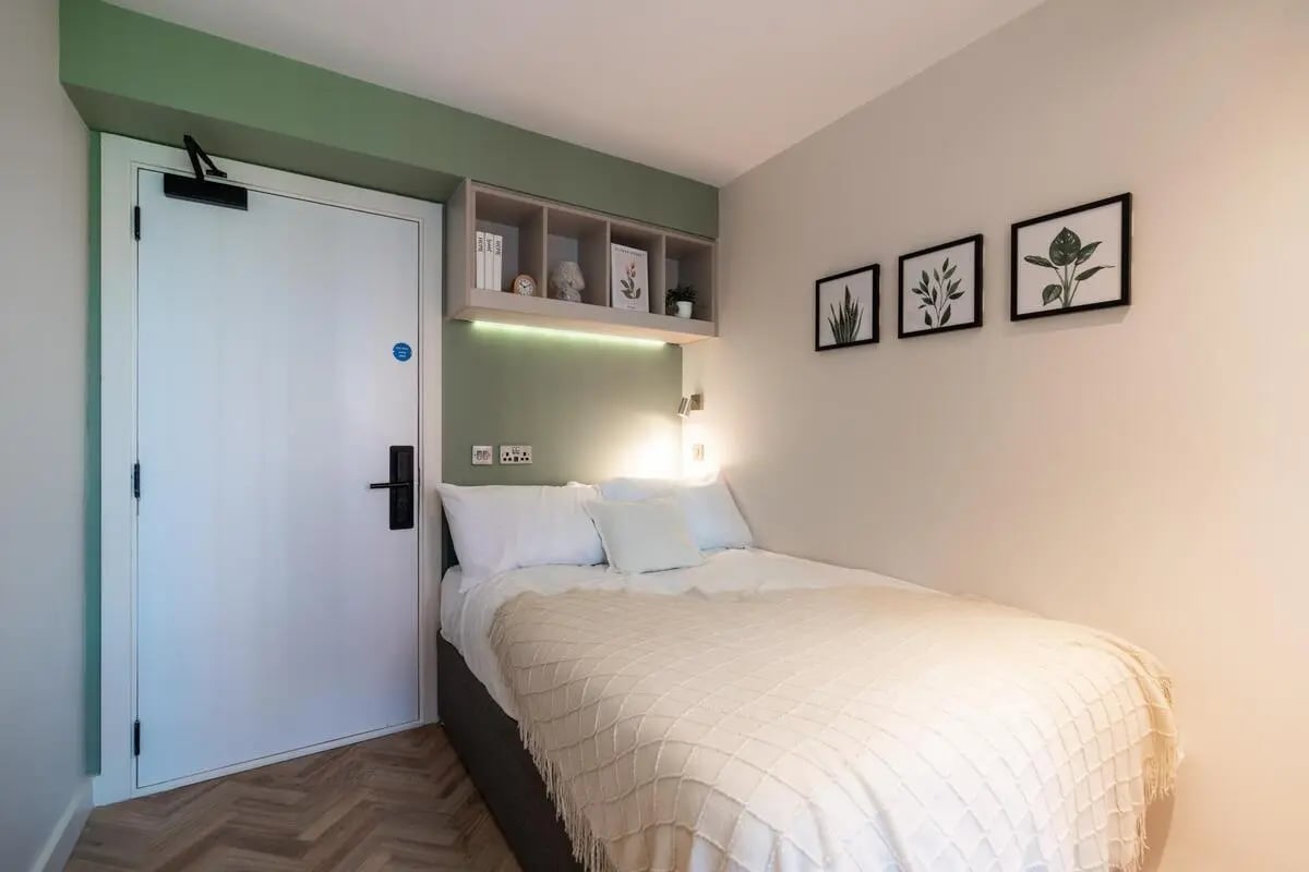 White door bed with plants bedroom at Arasain P&V in Dublin Student Accommodation