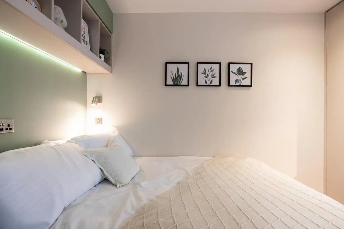 Bed with white linens and three framed plant prints Bedroom at Arasain P&V in Dublin Student Accommodation