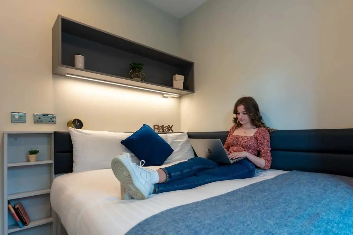 Bed with woman laptop shelf and decor bedroom at The Westwood in Galway Student Accommodation
