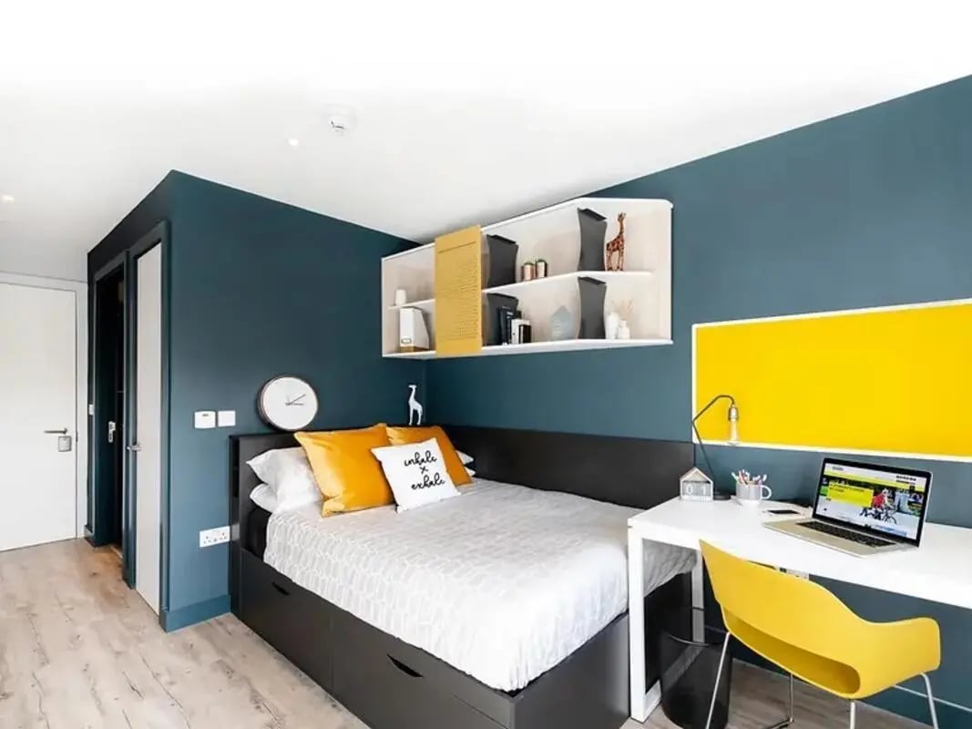 Bed desk yellow noticeboard wall shelves bedroom at Amnis House in Cork Student Accommodation